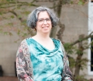 Fran Poodry seated and wearing a teal blouse